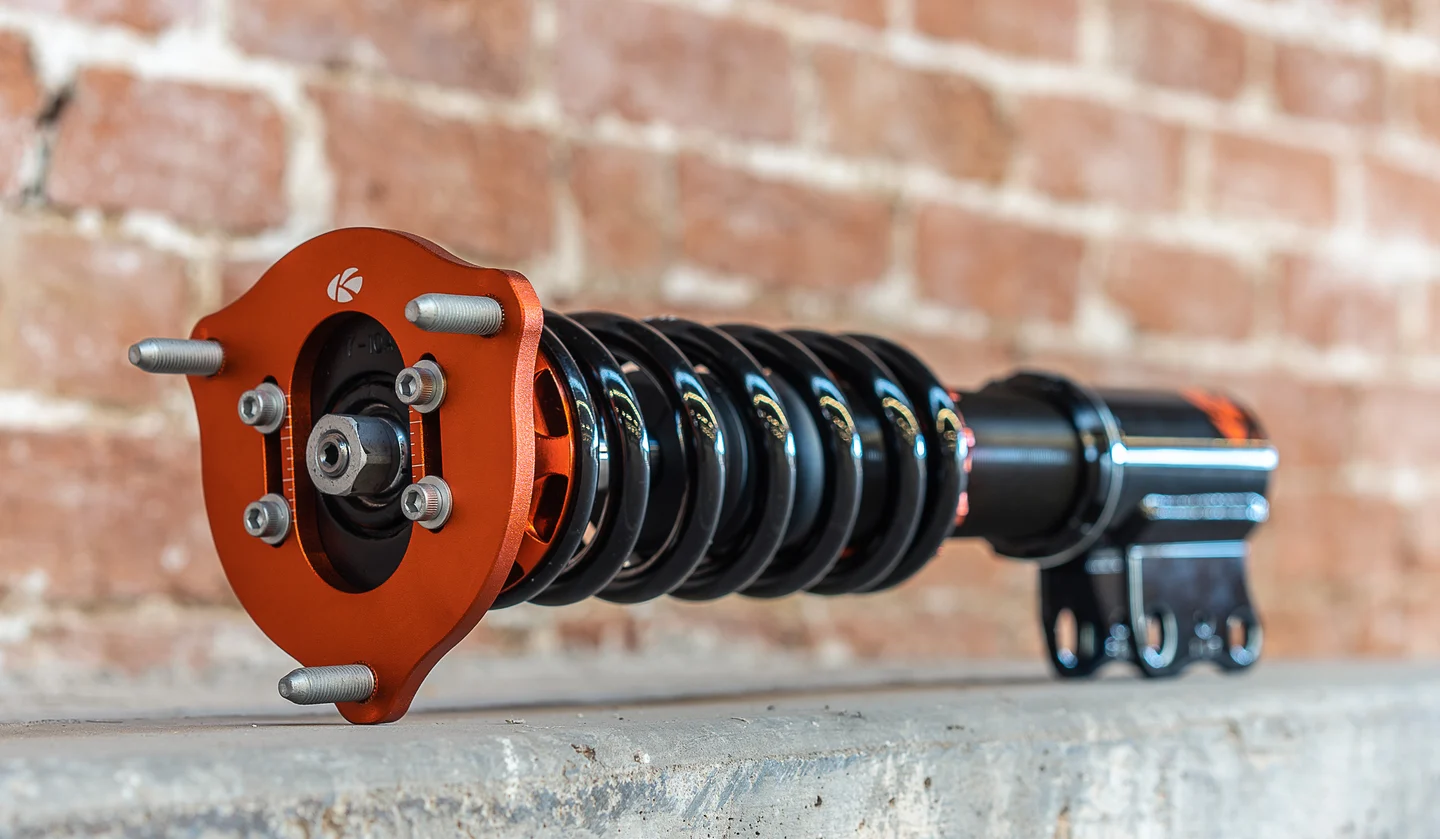 Original KSport Kontrol Pro coilover detail against brick