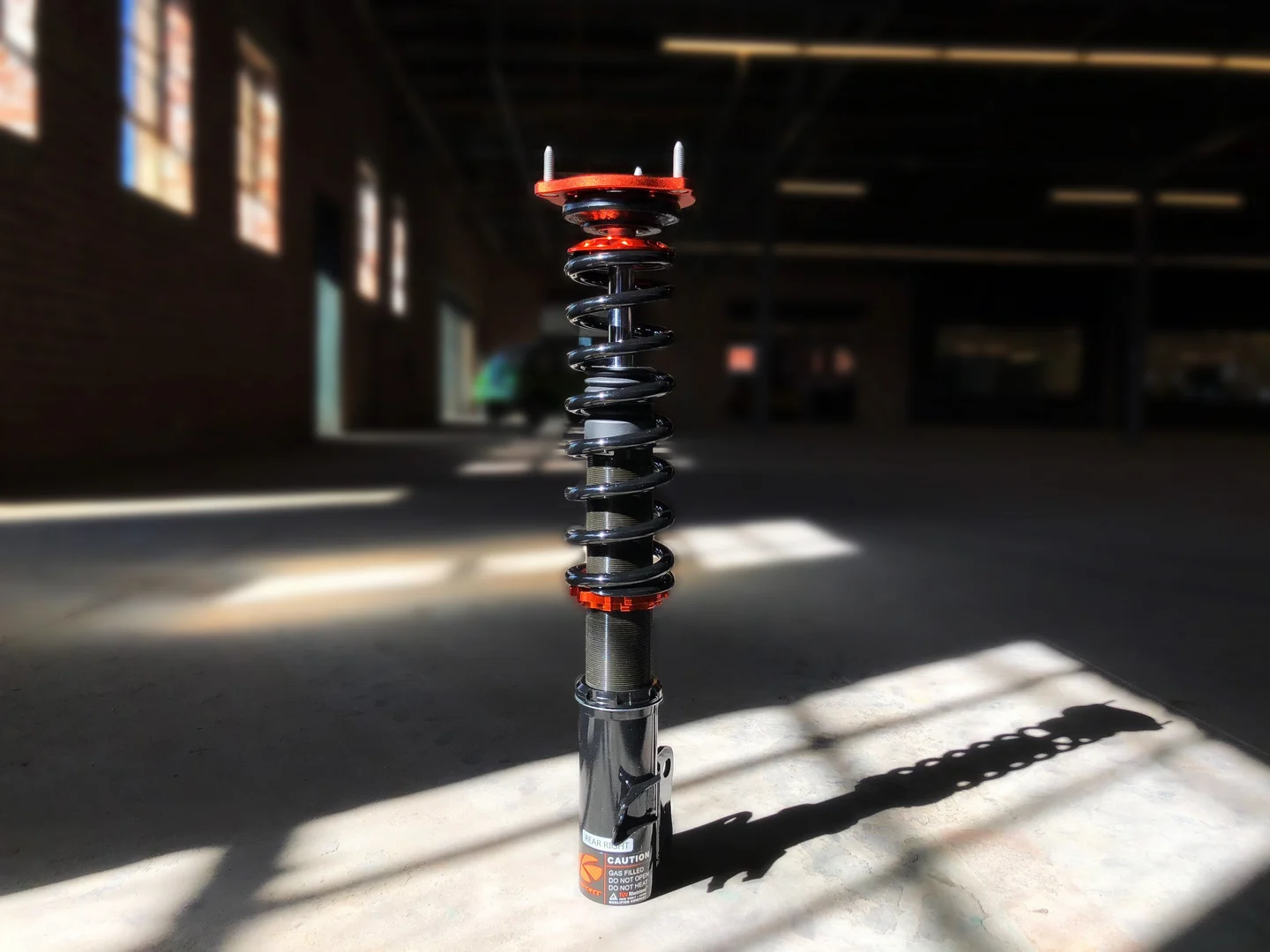 Genuine Kontrol Pro coilover in natural workshop light; complete hardware visible
